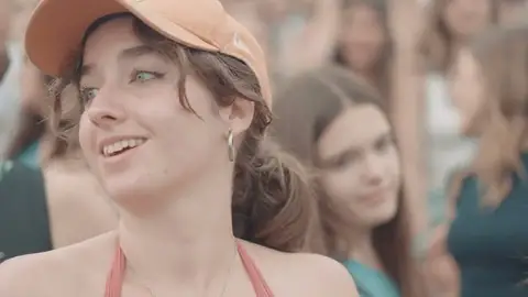 Chica sonriendo entre el público de un concierto