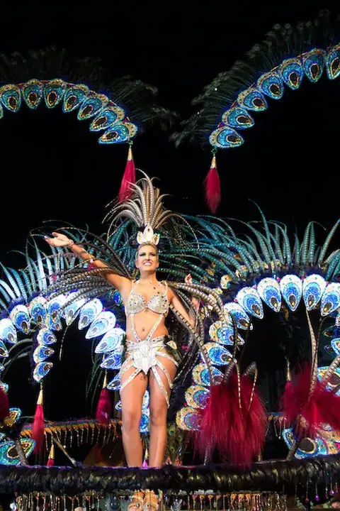 Reina del carnaval con traje de plumas en el escenario