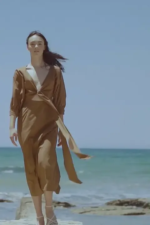 Modelo en la orilla durante el rodaje de un fashion film en Sicilia